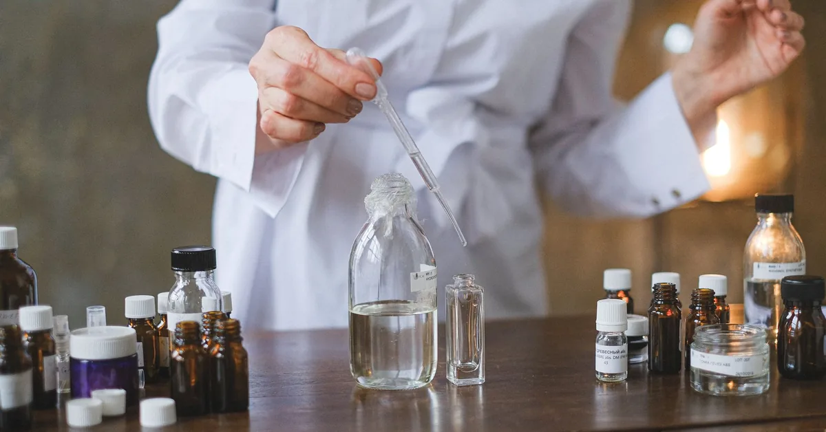 A researcher in a white coat handling sample vials in a laboratory
