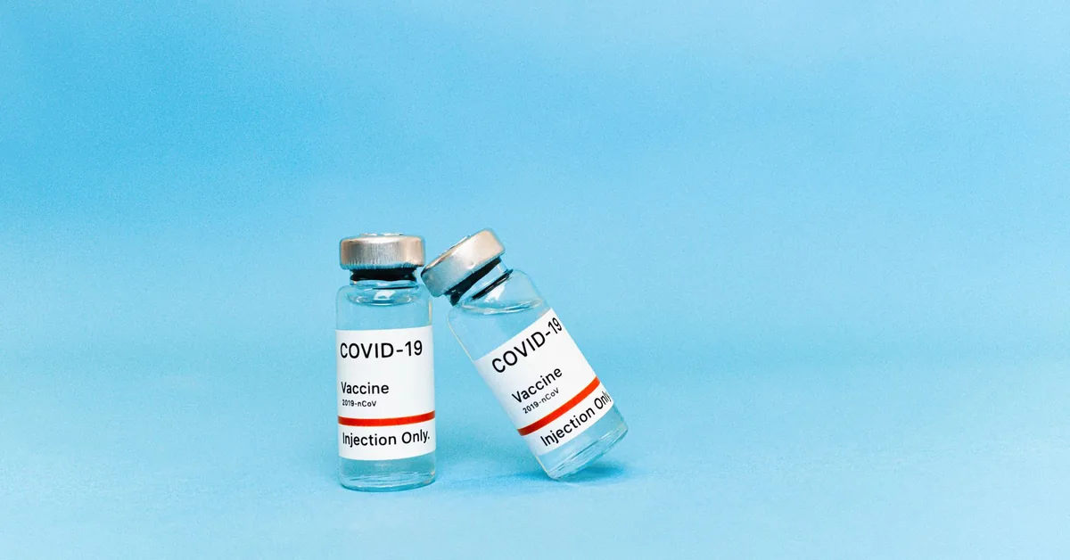 Two small glass medical vials standing on a blue background
