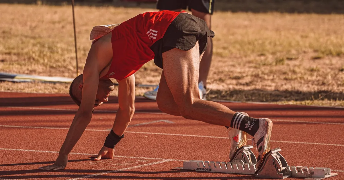 An athlete preparing to sprint on an outdoor track