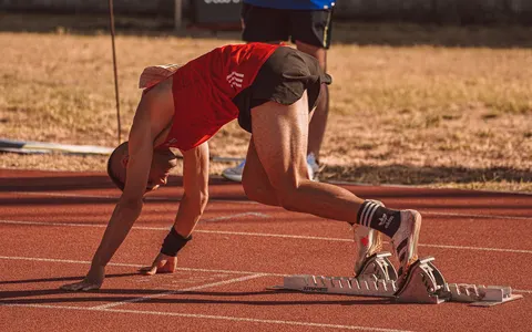 An athlete preparing to sprint on an outdoor track