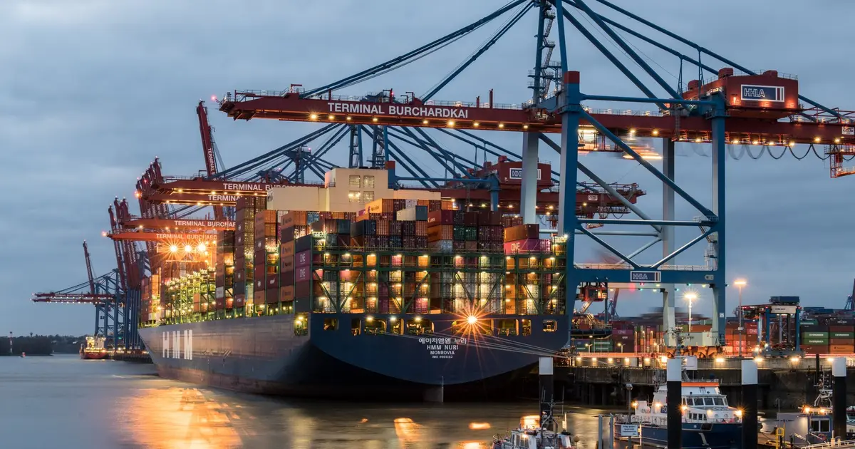 Container ships moored at a port terminal in the evening
