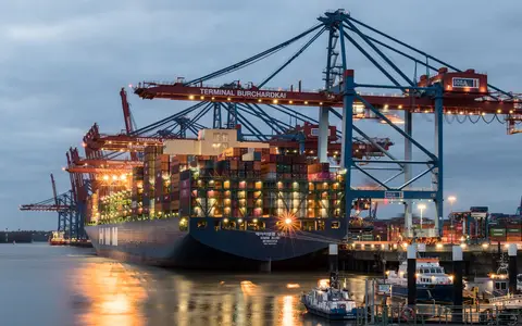 Container ships moored at a port terminal in the evening