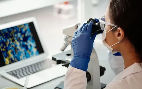 A scientist looking into a microscope in a research lab
