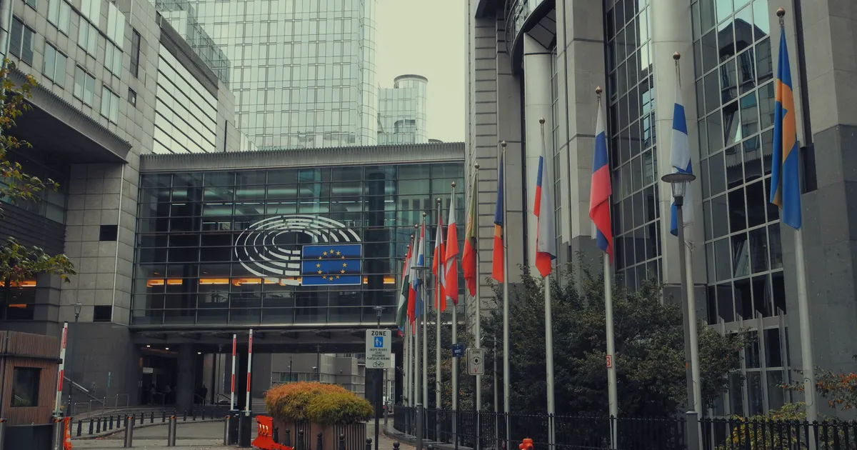 The European Parliament building in Brussels with EU flags