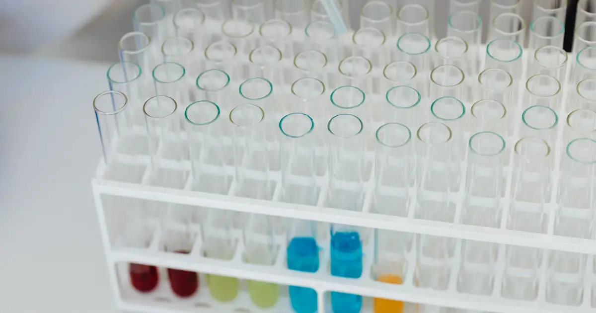 Close-up of a laboratory test tube rack with colorful chemical solutions, emphasizing scientific research