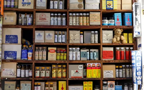 A vintage pharmacy shelf of old medicine bottles and boxes