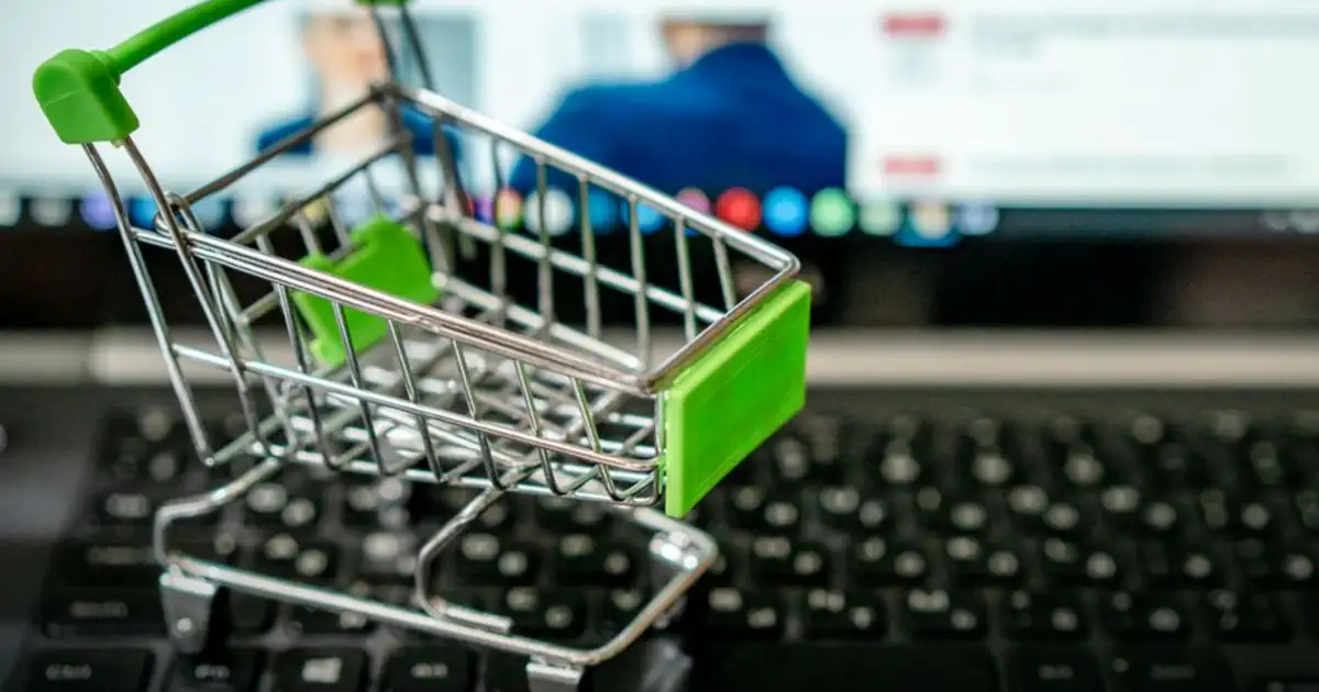 A miniature shopping cart on a laptop keyboard