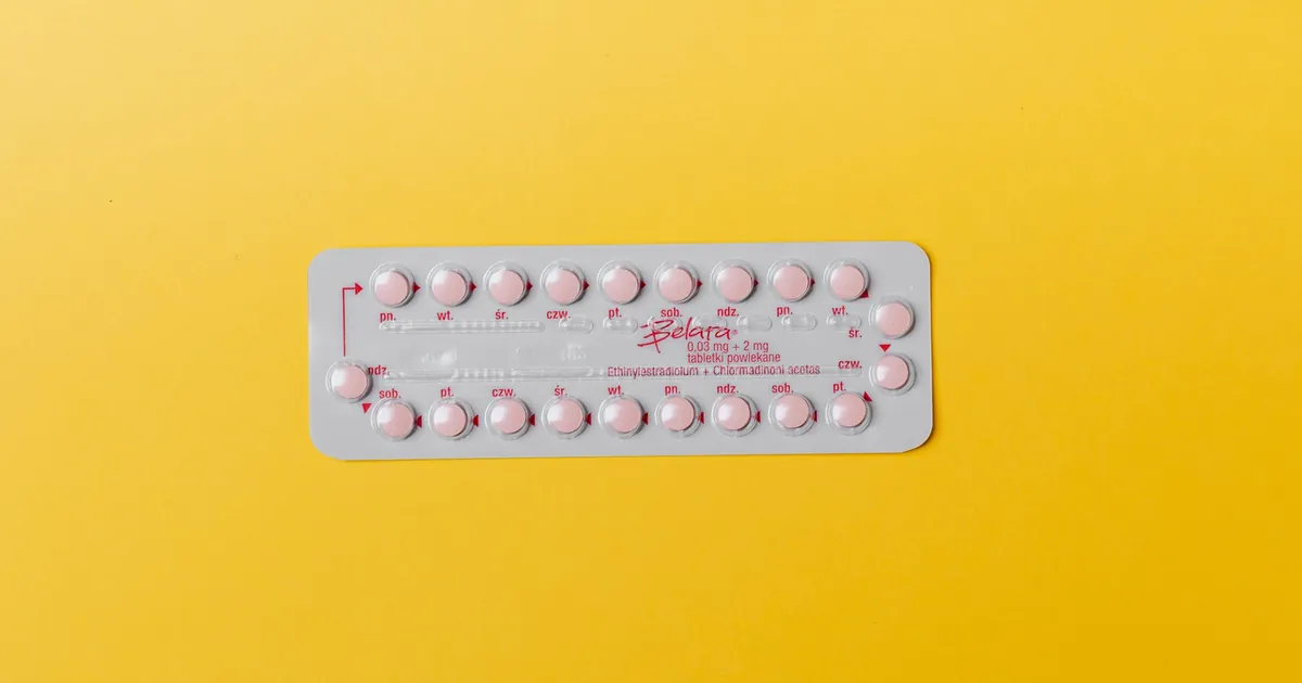Close-up of a blister pack of pink pills on a vivid yellow background for medication concept
