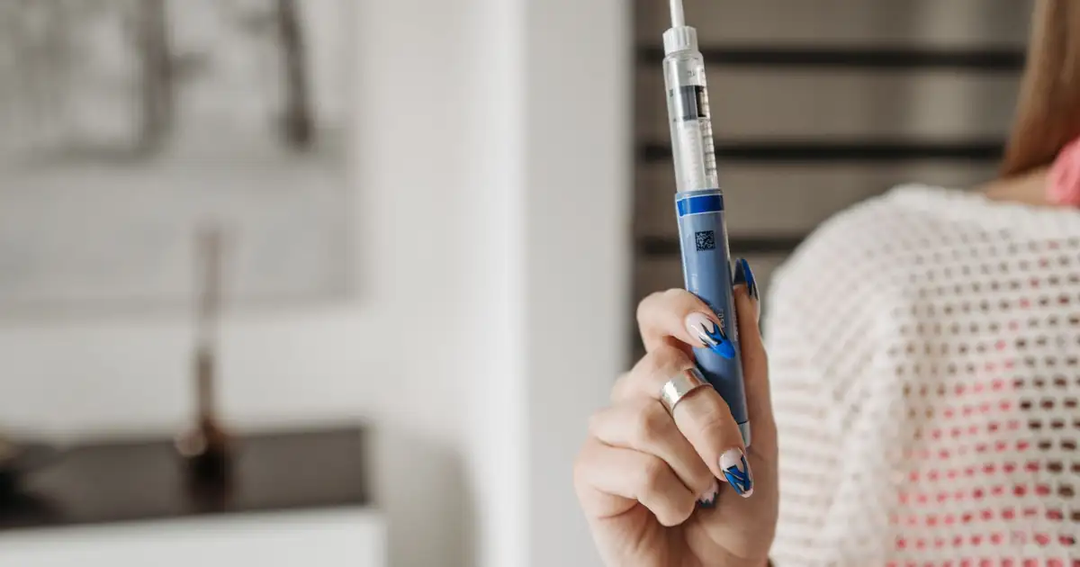 A woman holding an injection pen