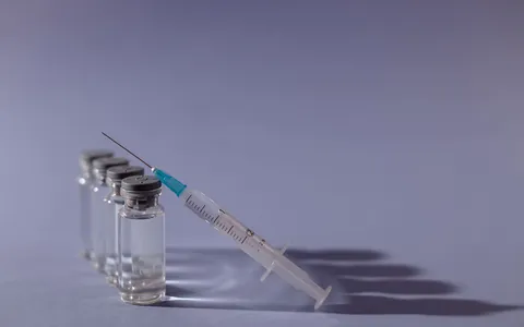 A pipette dispensing liquid into a row of small clear vials