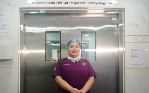 A healthcare professional standing in a hospital corridor