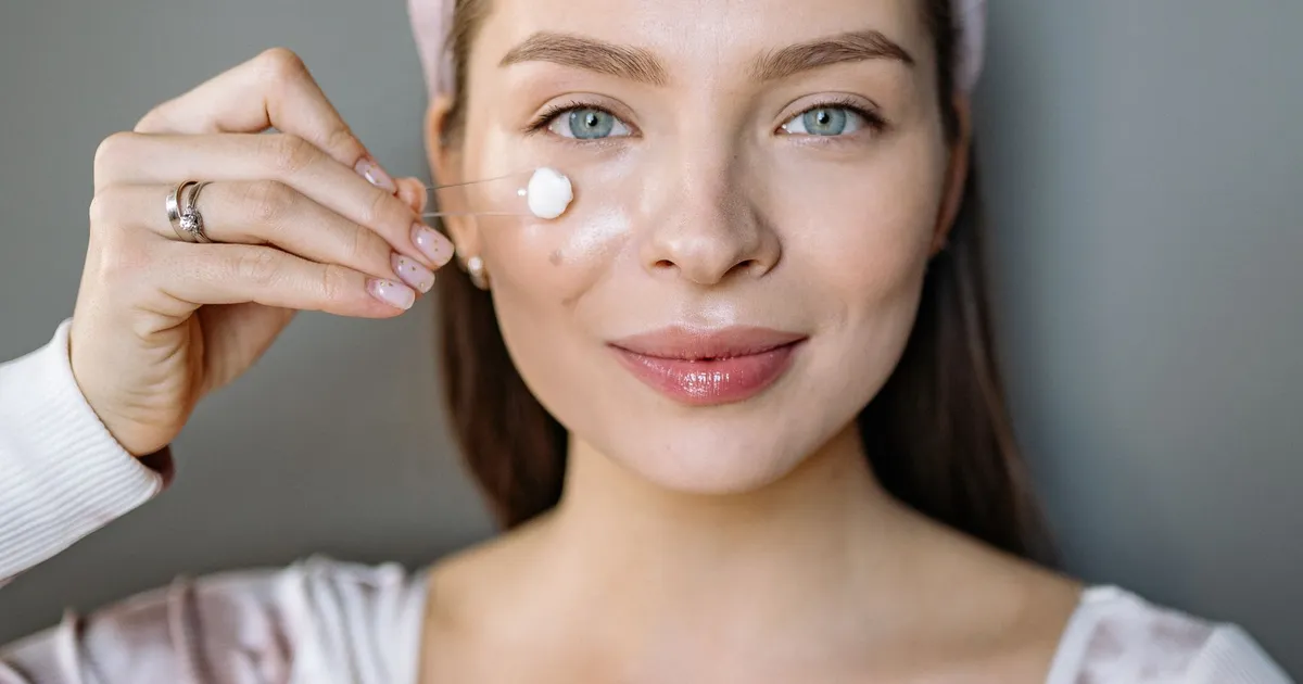 A woman applying face cream