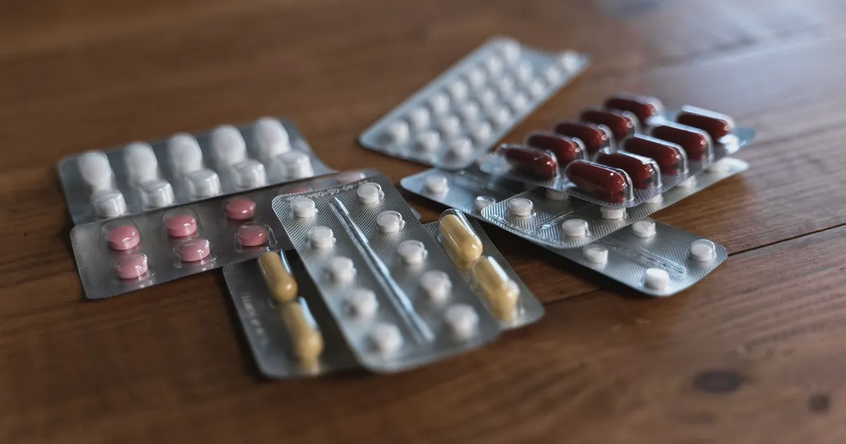 Assorted packs of pills on a wooden table