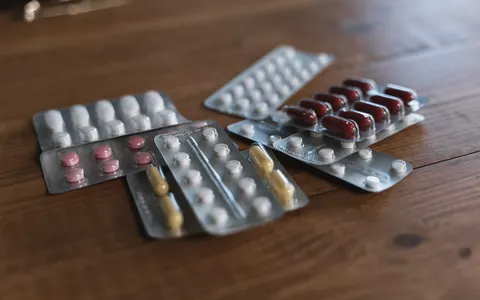 Assorted packs of pills on a wooden table