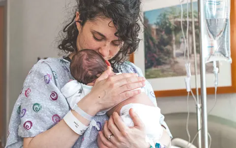 A mother holding her newborn baby in hospital