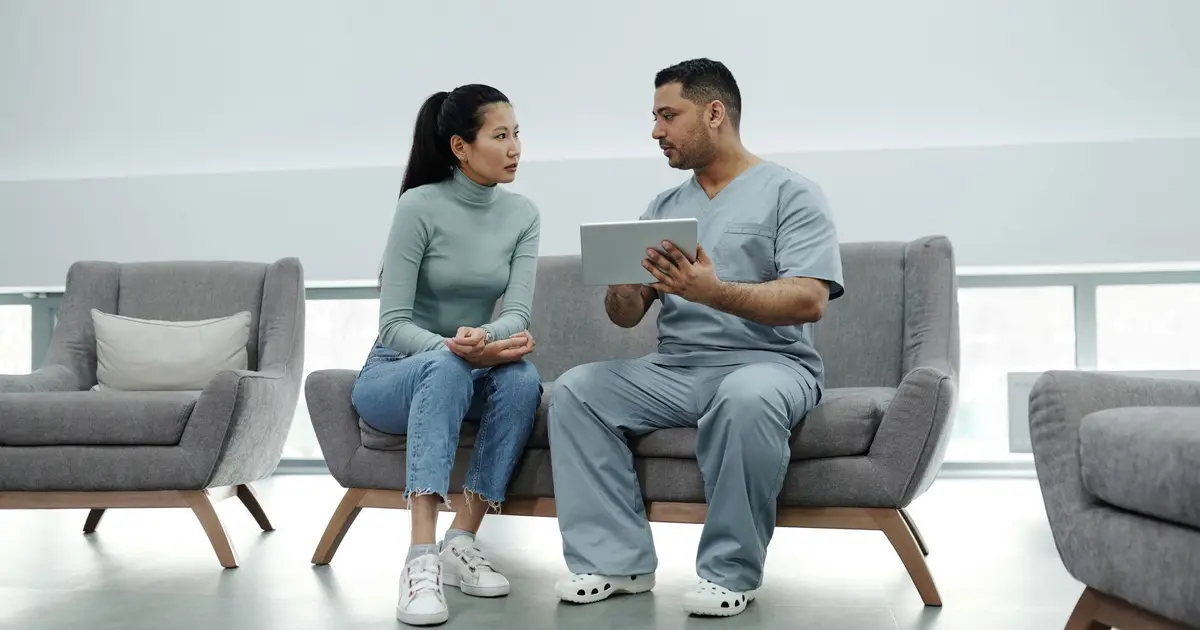 Healthcare provider consulting a patient with a tablet, emphasizing technology in healthcare