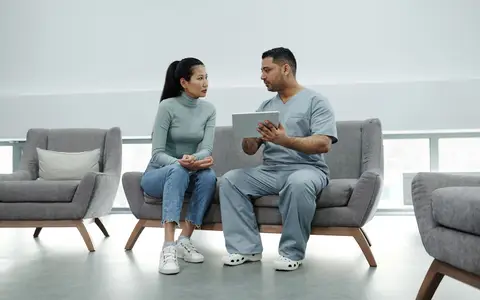 Healthcare provider consulting a patient with a tablet, emphasizing technology in healthcare