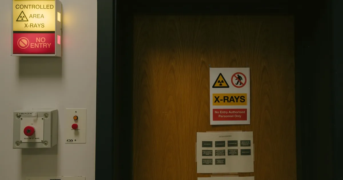 A door with warning signs marking a controlled radiation area in a hospital