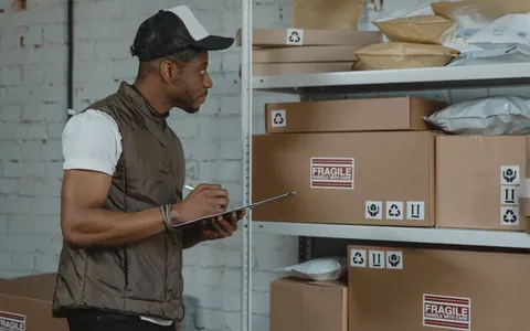 A courier checking packages in a warehouse