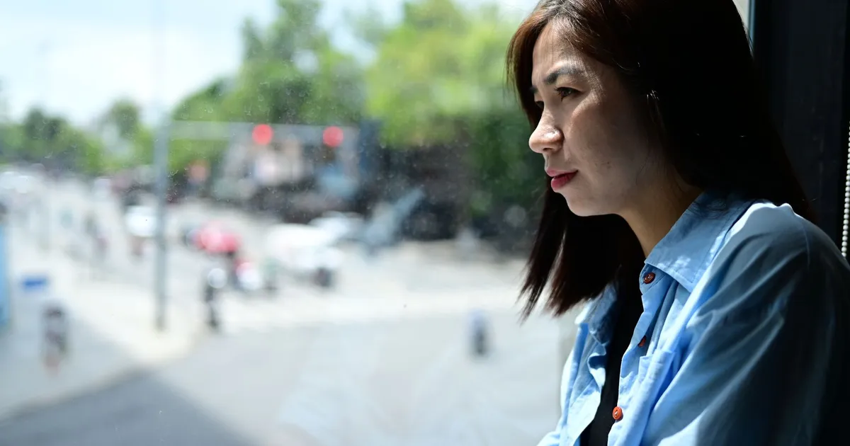 A thoughtful woman gazing out of a window onto a busy street