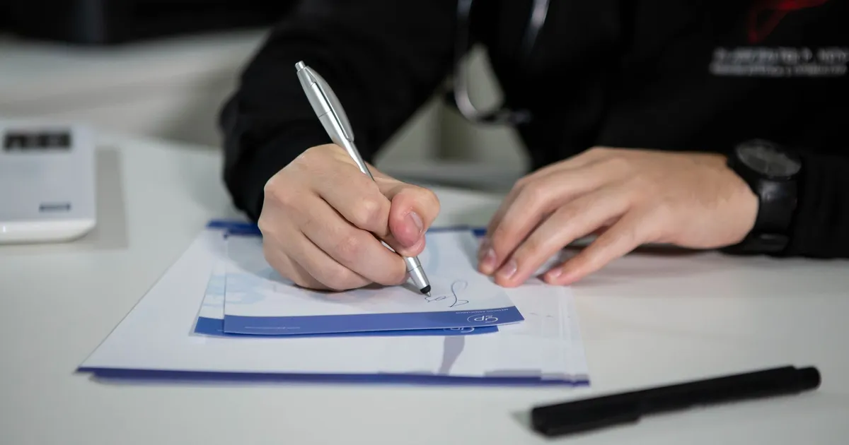 A clinician writing a prescription on paper in a clinic