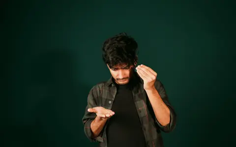 A young man examining hair loss indoors, reflecting self-care concerns