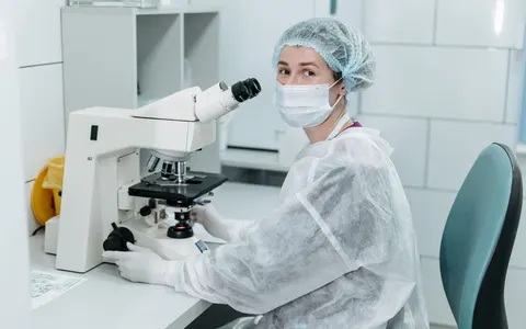 A scientist using a microscope in a sterile laboratory