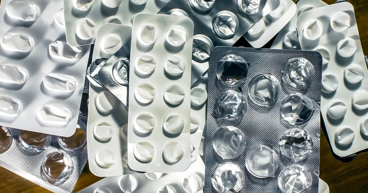 Close-up of empty medication blister packs on a wooden surface