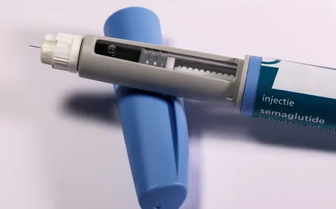 A blue injection pen lying on a neutral surface