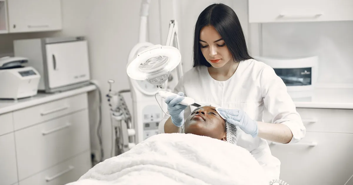 An aesthetician giving a client a facial treatment