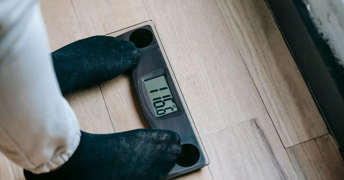 A person's feet standing on a bathroom weighing scale