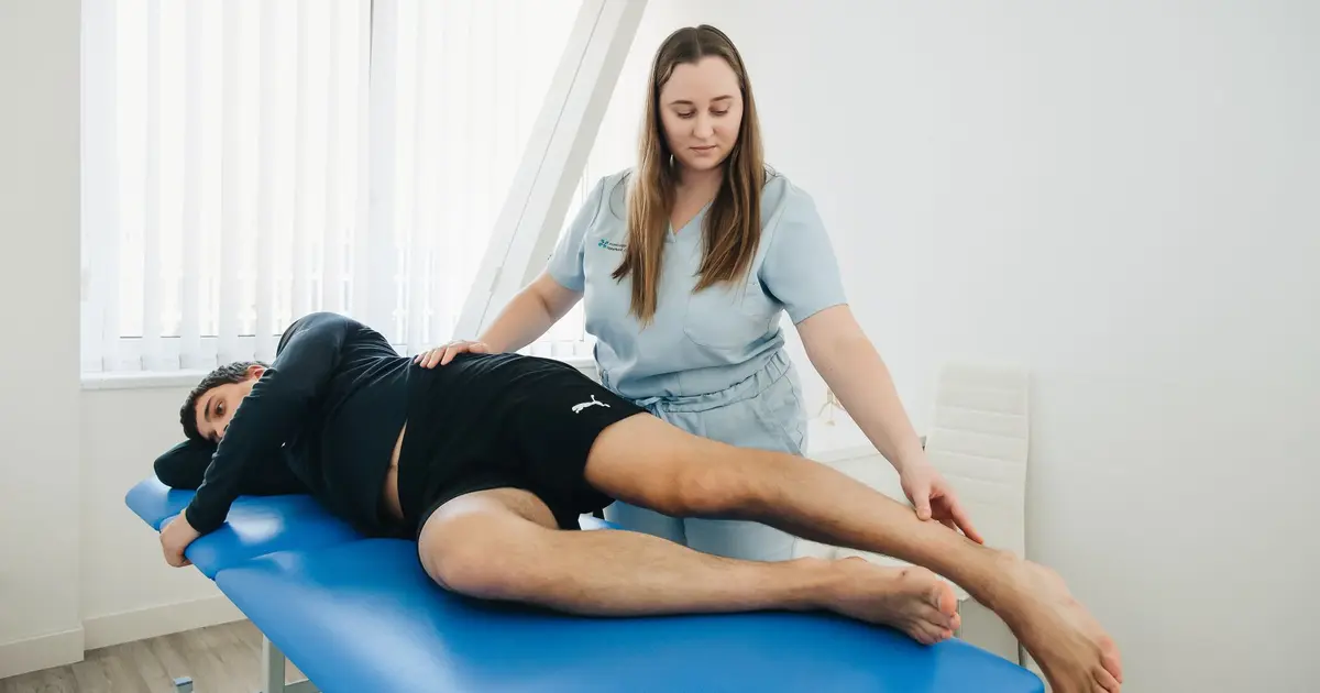 A physiotherapist assists a patient in a rehabilitation session at a Vilnius clinic