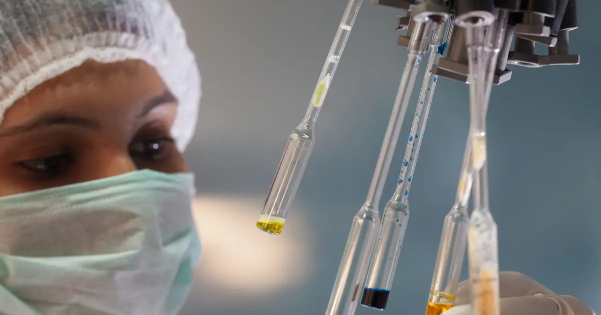 Woman scientist in lab handling test tubes with precision and focus
