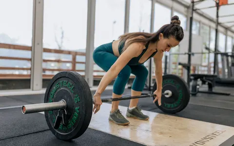 A woman preparing to lift a barbell in a gym